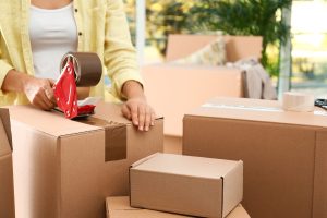 Woman Packing Box Indoors, Closeup. Moving Day